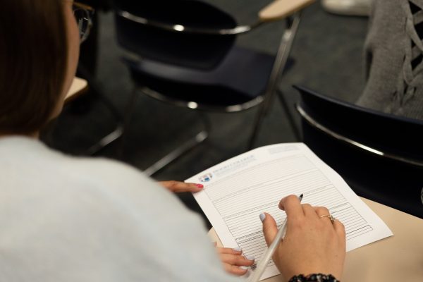 Photo of a piece of paper on a desk with a handwriting on it